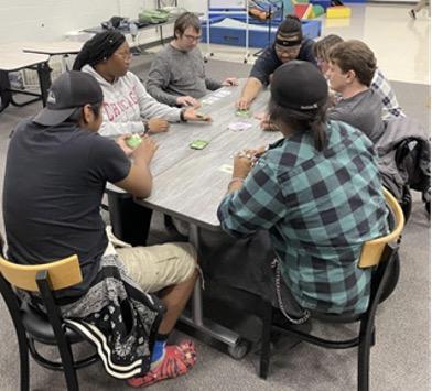 TR students play cards with Longwood Life students.