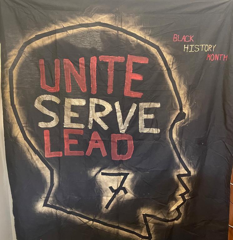 An image of a flag with Black history month in the top right corner in all capital letters Red text is Black, History text is Yellow and Month text is Red. The words 