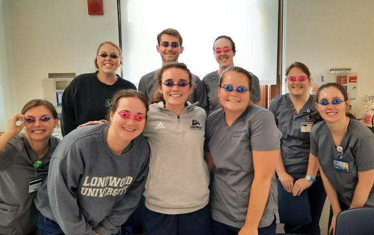 Nursing students wear goggles and pose for a group photo.