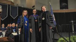 Longwood faculty in academic regalia stand onstage during Convocation.