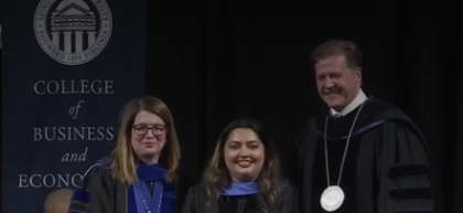 Longwood faculty in academic regalia stand on stage during Convocation